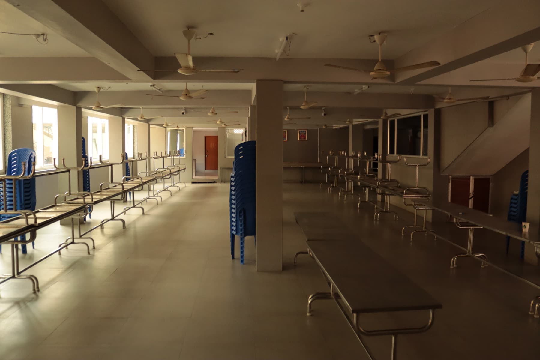Dining hall with long steel tables and seating